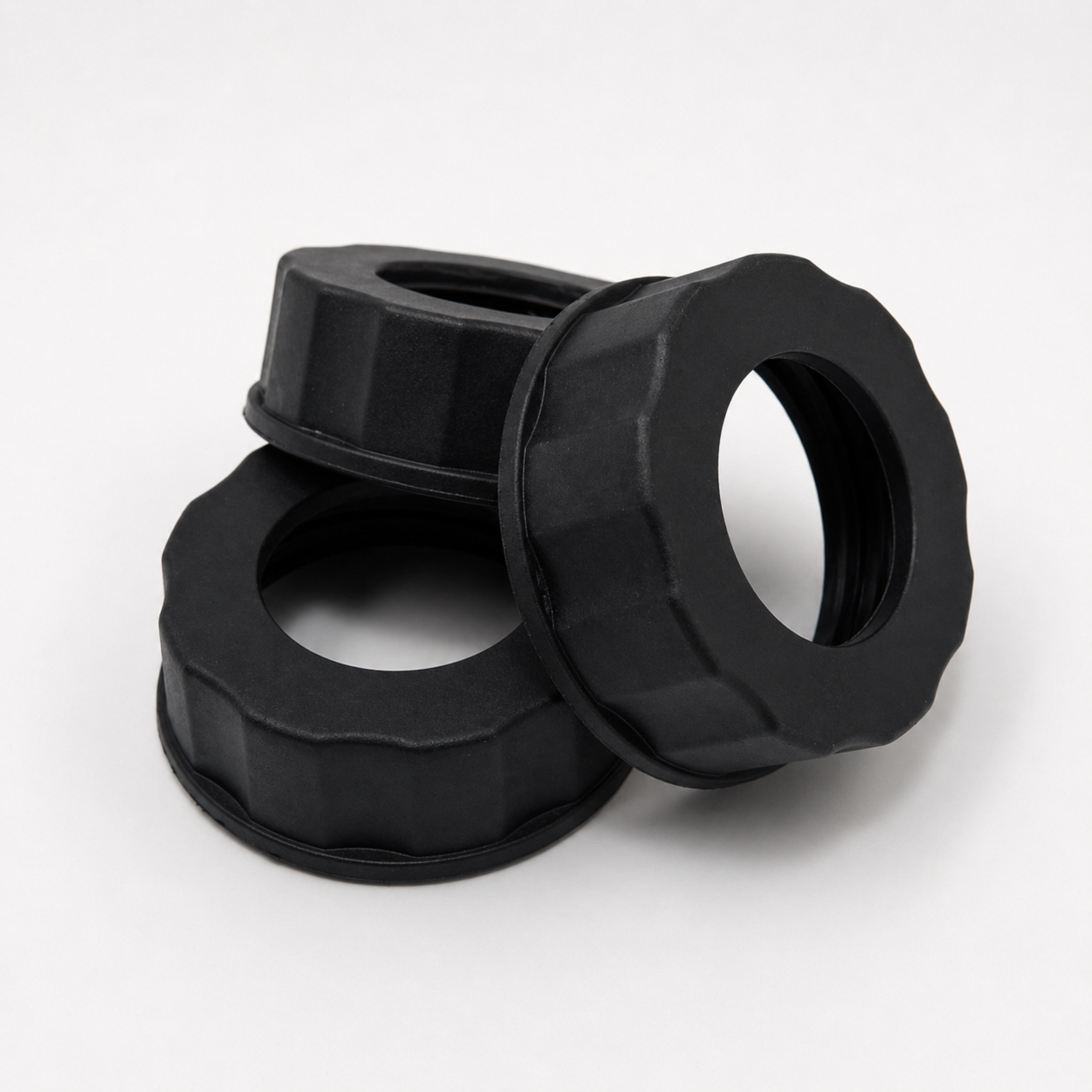 Three black plastic washers stacked on a white background