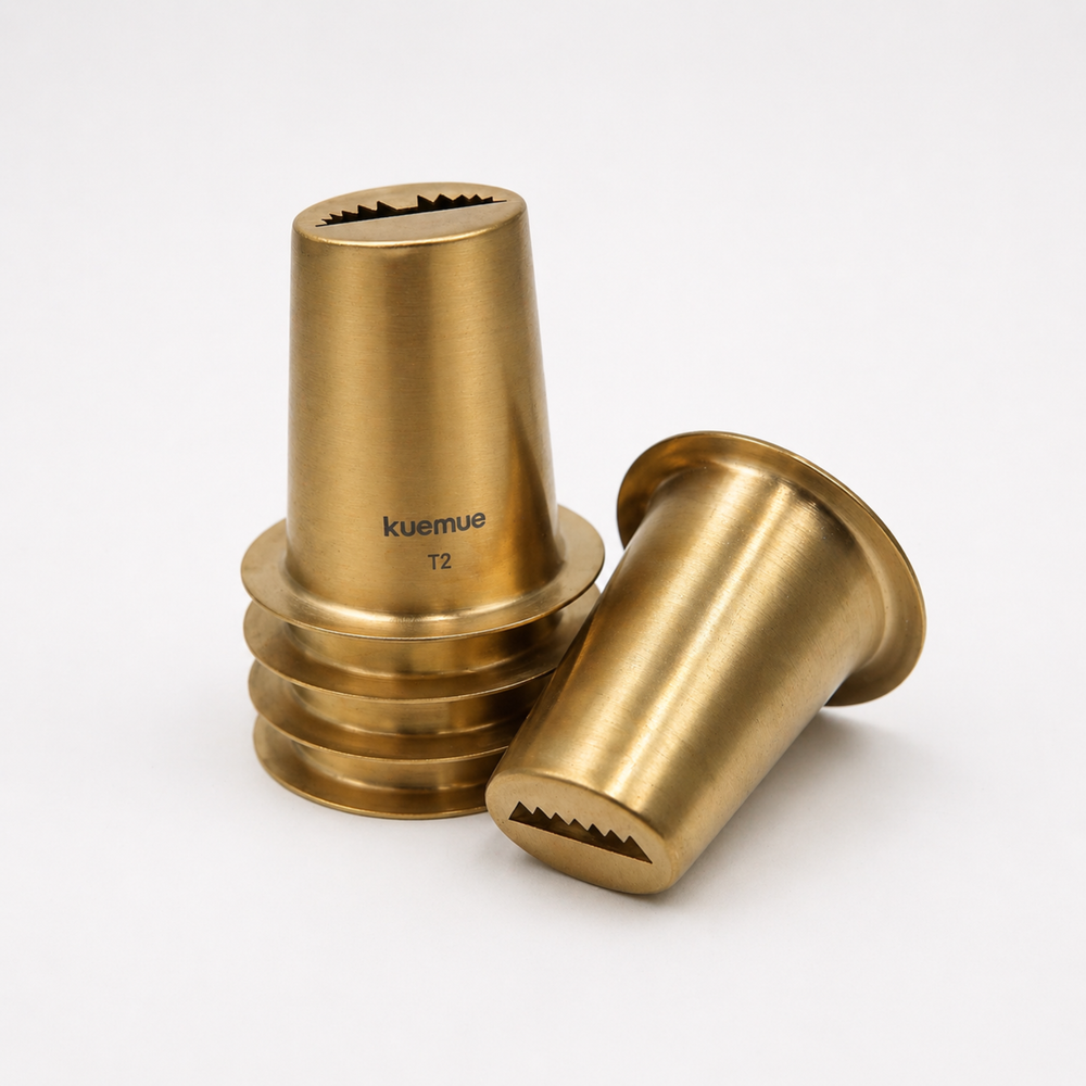 Two brass-colored metal components with 'kuemue' branding on a white background