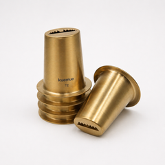 Two brass-colored metal components with 'kuemue' branding on a white background